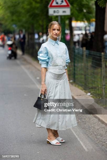 Victoria Magrath wears blue button shirt, laced dress, black bag 